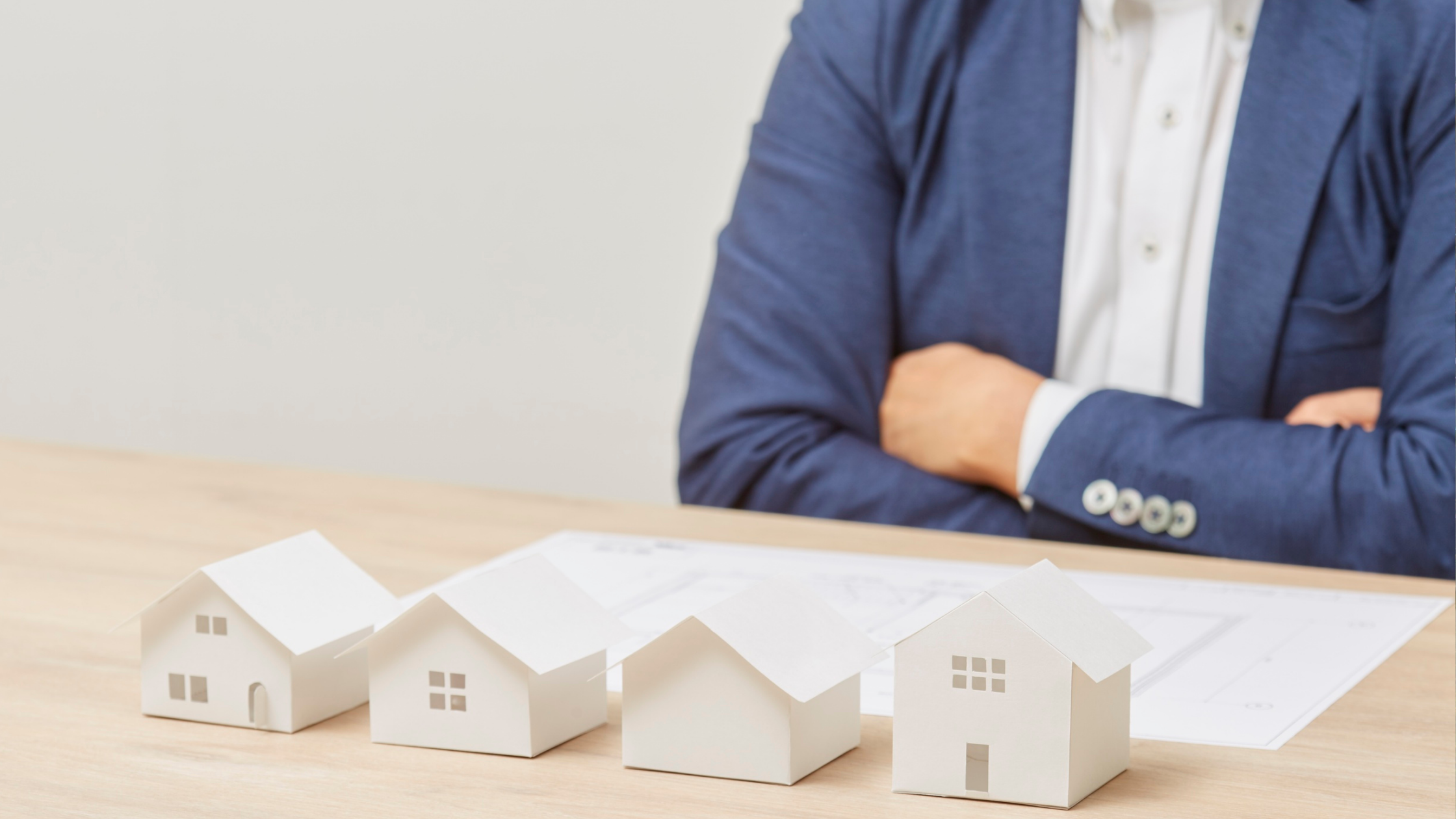 stock image of person in blue jacket with houses in front of them